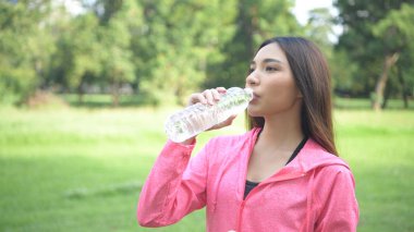 Egzersiz kavramları. Kız egzersizden sonra su içmek için dinleniyor.