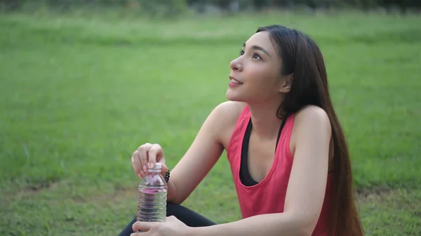 Conceptos de ejercicio.La chica está descansando para beber agua después del ejercicio. —  Fotos de Stock