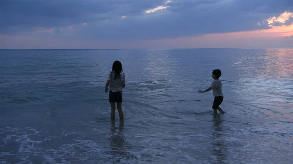 Conceito de férias. As irmãs e os irmãos estão brincando no mar — Fotografia de Stock
