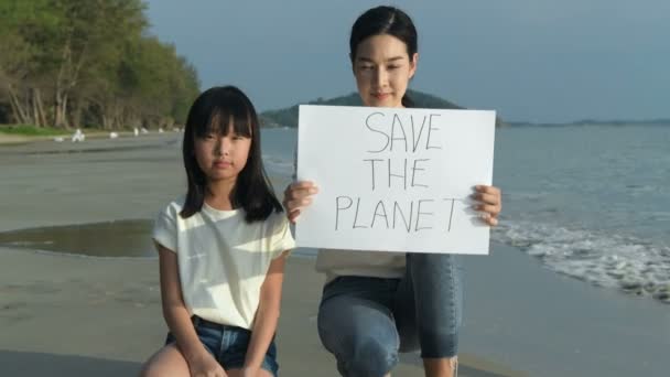 キャンペーンコンセプト 女の子はビーチで深刻な顔で世界を愛するためのバナーを持っています 4K分解能 — ストック動画