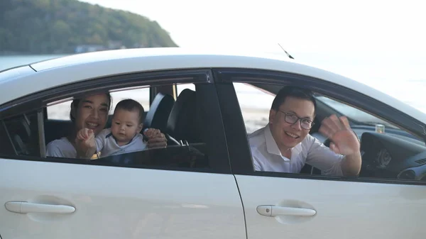 Holiday concept. The family waved goodbye inside the white car o