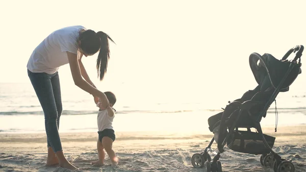 Koncepcja święta. Matka uczy dziecko chodzić po plaży. 4 — Zdjęcie stockowe