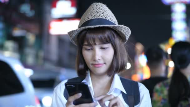 旅行のコンセプト 美しい女の子は夜に街で楽しむために携帯電話を果たしています 4K分解能 — ストック動画