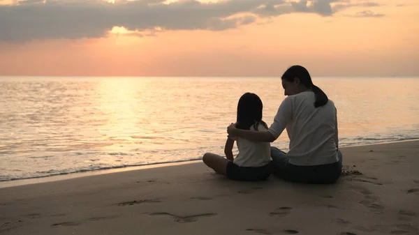 Concept de vacances. Mère et fille regardent le coucher du soleil sur — Photo