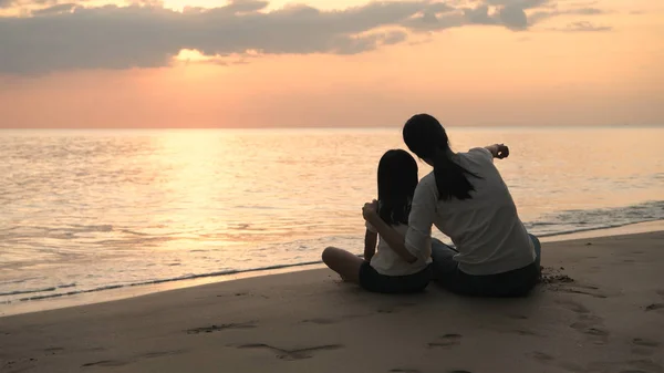 Conceito de férias. Mãe e filha estão a ver o pôr-do-sol — Fotografia de Stock