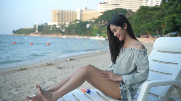 Conceito de férias. Menina bonita aplicando protetor solar na praia . — Fotografia de Stock