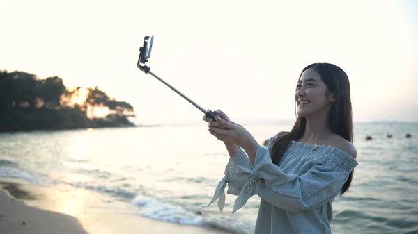 Concepto de vacaciones. Hermosa chica llamando vídeo en el móvil a la b — Foto de Stock