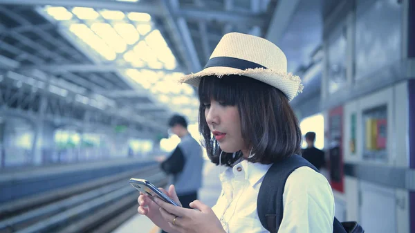 Concetto turistico. Una donna asiatica sta aspettando il treno al — Foto Stock