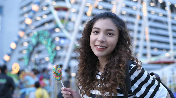 Concepto de vacaciones. Hermosas chicas están comiendo piruletas felices en —  Fotos de Stock