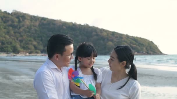 假期的概念 父母和女儿在海滩上玩风力涡轮机 4K分辨率 — 图库视频影像