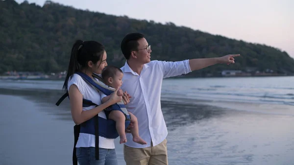 Concepto de vacaciones. La familia está viendo la puesta de sol en la playa . — Foto de Stock