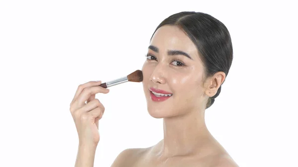 Beauty concept. A beautiful woman is using a brush to brush her — Stock Photo, Image