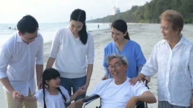Tatil konsepti. Büyük bir aile sahilde güzel bir sohbet ediyor. 4k Çözünürlüğü.