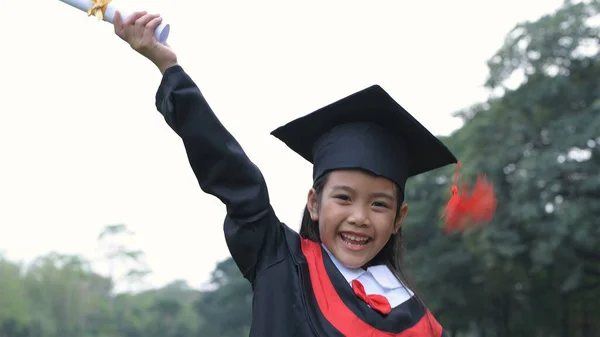 Conceptos educativos. La chica que lleva el vestido de graduación es h —  Fotos de Stock