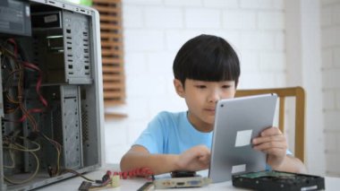 Öğrenme kavramları. Çocuk evdeki bilgisayarı tamir etmeyi öğreniyor. 4k Çözünürlüğü.