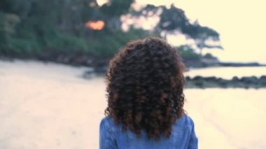 Tatil konsepti. Güzel kız sahilde mutlu bir şekilde yürüyor. 4k Çözünürlüğü.