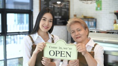 Kahve dükkanı konsepti. Kahve dükkanı sahibi servisi açmak için tabelayı kaldırıyor. 4k Çözünürlüğü.