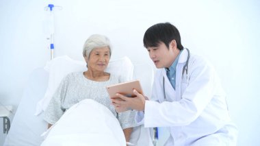 Tıbbi kavramlar. Doktor hastanede bir tablet kullanarak tedaviyi hastaya tanımladı. 4k Çözünürlüğü.