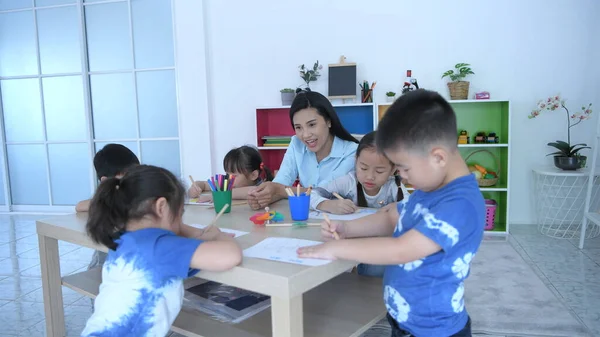 Bildungskonzepte Die Lehrerin Bringt Kindergartenkindern Bei Klassenzimmer Bilder Malen Auflösung Stockbild