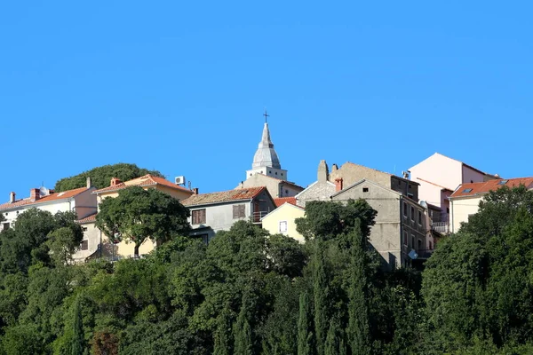 地中海古城 在当地天主教教堂周围 到处都是密集的石砌房屋 耸立在高高的小山上 周围环绕着茂密的森林和蓝蓝的天空 — 图库照片