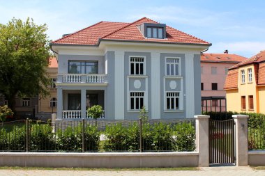 Şehrin eski bir bölgesinde, yeni inşa edilmiş eski tip bir aile evi. Etrafı metal çit ve çimlerle çevrili. Küçük dekoratif bitkilerle dolu.