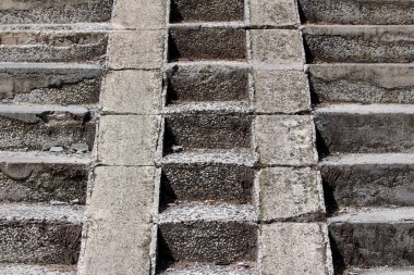 Kamu parkının arka planında dar bisiklet izleri olan kırık, eski, kirli beton basamakların dokusu