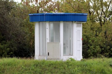 Yuvarlak endüstriyel su pompalama istasyonu kontrol odası. Geniş cam pencerelerden yapılmış. Metal mavi çatıyla kaplı.