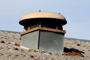 Endüstriyel havalandırma her tarafta metal ağ koruması ile kapalı ve terk edilmiş sanayi binasının tepesinde büyük yuvarlak metal kaplama ile kaplı.