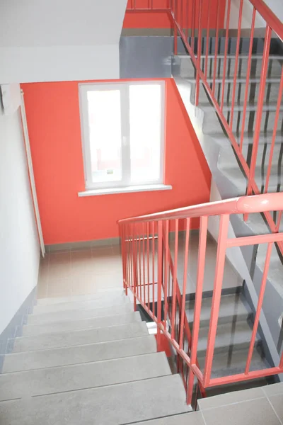 Luz de la ventana de las escaleras en un nuevo edificio de varios pisos. Entrada limpia, color naranja —  Fotos de Stock