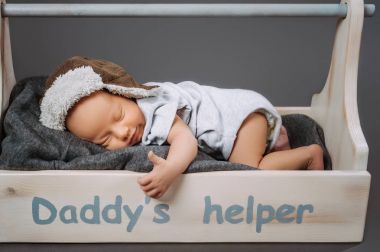 sevimli bebek bebek başparmak gösterilmesini harfler daddys yardımcı ile ahşap araç kutusunda uyurken
