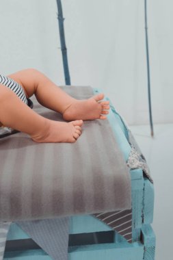 cropped shot of little baby lying on bed clipart