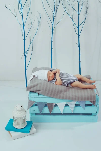 可爱的新生婴儿在衣和帽子睡在木盒附近的灯笼 — 图库照片