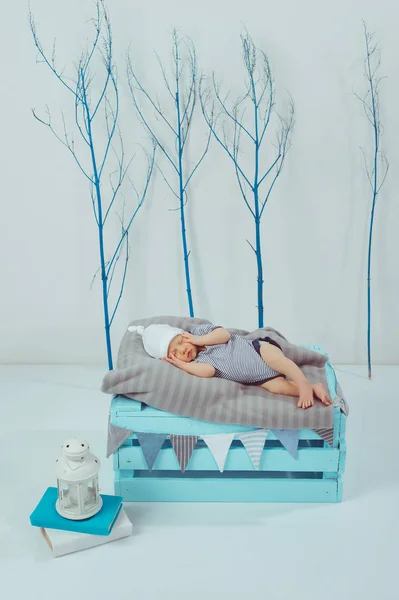 可爱的新生婴儿在衣和帽子睡在木盒附近的灯笼 — 图库照片