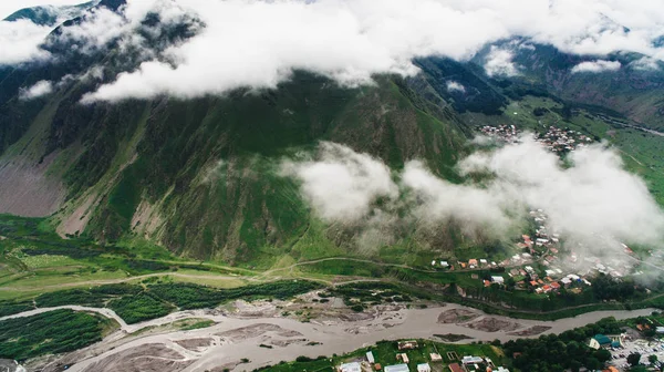 Ville dans les montagnes verdoyantes avec rivière — Photo de stock