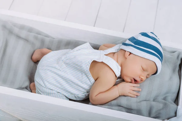 High angle view of cute newborn baby sleeping in wooden baby crib — Stock Photo