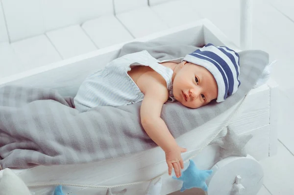 Innocent little infant baby lying in wooden baby cot — Stock Photo