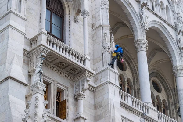 Homme travaillant sur un vieux bâtiment du Parlement hongrois à Budapest — Photo