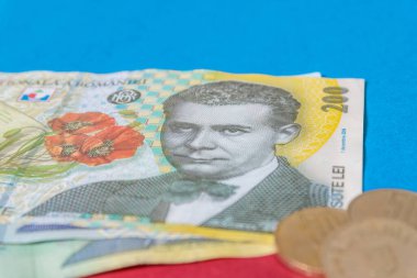 Romen banknotları ve paraları mavi ve kırmızı arka planda. Romen Para Birimi 'nden Ron Coloseup. Romanya Merkez Bankası Bnr tarafından yayınlanan Rumen Ron ve Lei Banknotes. Romanya Maliye ve Ekonomi Konsepti.