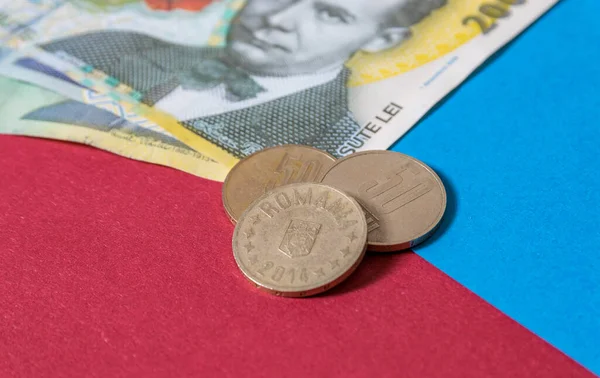 Romen banknotları ve paraları mavi ve kırmızı arka planda. Romen Para Birimi 'nden Ron Coloseup. Romanya Merkez Bankası Bnr tarafından yayınlanan Rumen Ron ve Lei Banknotes. Romanya Maliye ve Ekonomi Konsepti.