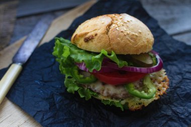 Ev yapımı hamburger taze domates, marul, soğan ve patates kızartması rustik ahşap tahta üzerinde. Fast food, sağlıksız yeme