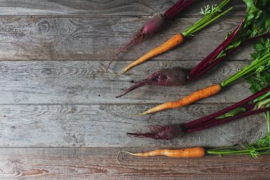 Top görünümü taze organik pancar ve rustik ahşap arka plan, sağlıklı yaşam, sonbaharda hasat, çiğ sebzeler, havuç