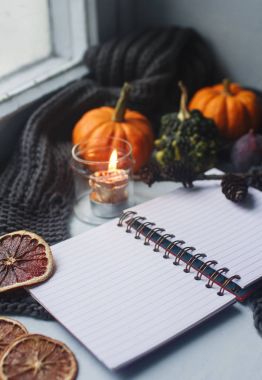 Rahat sonbahar arka plan, defter, dekoratif pumpkins, kurutulmuş portakal, mum, fındık, tarçın ve sonbahar yaprakları