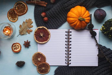 Rahat sonbahar arka plan, defter, dekoratif pumpkins, kurutulmuş portakal, mum, fındık, tarçın ve sonbahar yaprakları