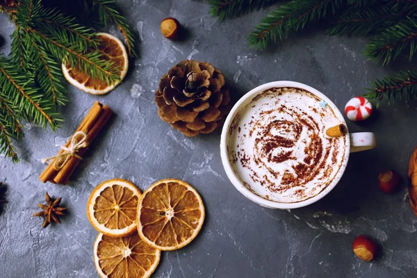 Fincan kakao ya da krem, tarçın, Kuru portakal, sıcak eldiven ve köknar ağacı karanlık taş masada sıcak çikolata