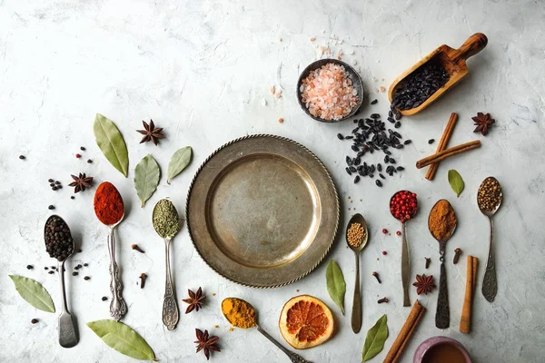 Különböző színes indiai fűszerek és gyógynövények a silver kanalak, fehér háttér — Stock Fotó