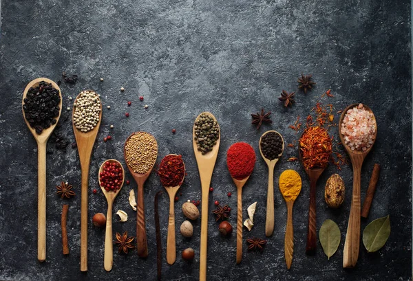 Varias especias indias en cucharas de madera, hierbas y frutos secos — Foto de Stock