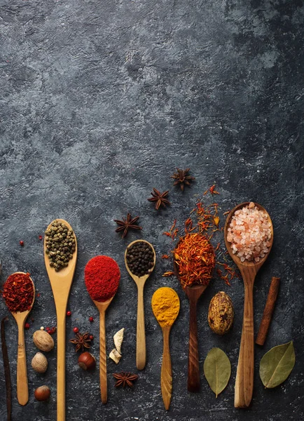 Varias especias indias en cucharas de madera, hierbas y frutos secos — Foto de Stock