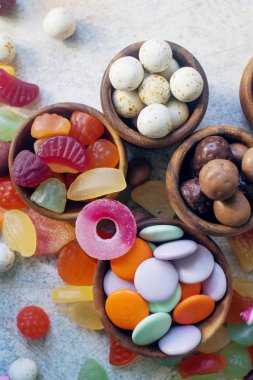 Beyaz masada çocuklar için renkli, parlak, çeşitli şekerler ve şekerler.