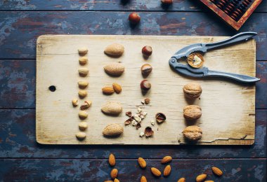 Koyu ahşap masa, ceviz, badem, fındık, fındık, fındık, çeşitli sağlıklı yiyeceklerin karışımı, üst görünüm, seçici odaklanma.