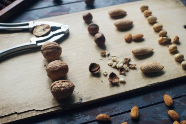 Koyu ahşap masa, ceviz, badem, fındık, fındık, fındık, fındık, çeşitli sağlıklı yiyeceklerin karışımı.